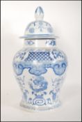 A tall 20th Century Chinese blue and white lidded ginger jar of bulbous form. The jar transfer