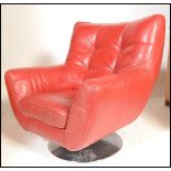 A 20th Century red leather swivel easy lounge armchair, spoon back with scroll arms raised on a