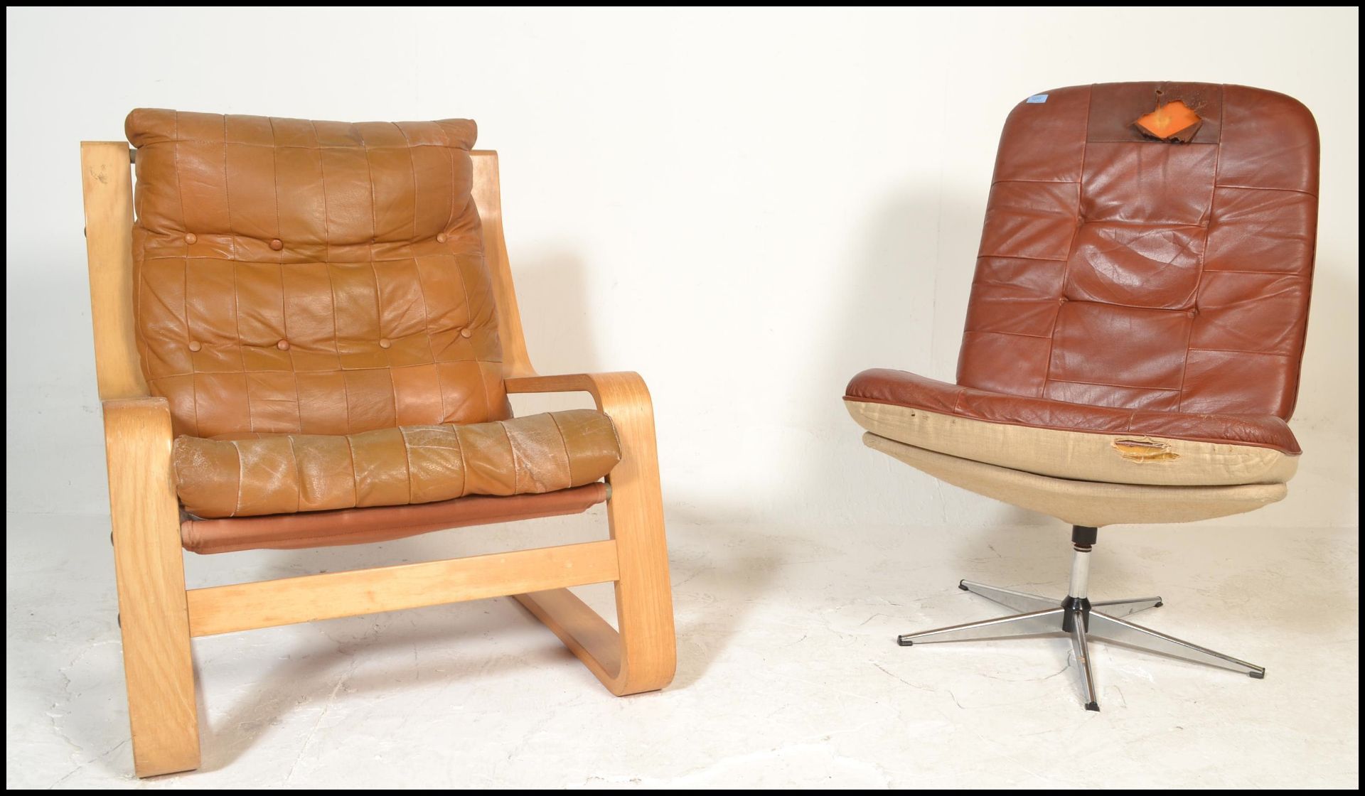 A mid century Danish oxblood leather swivel armchair being raised on a five point chrome base