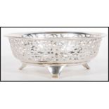 A early 20th Century silver hallmarked dish having pierced foliate decoration raised on three