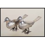 A pair of silver white metal salt and pepper condiments in the form of birds having engraved