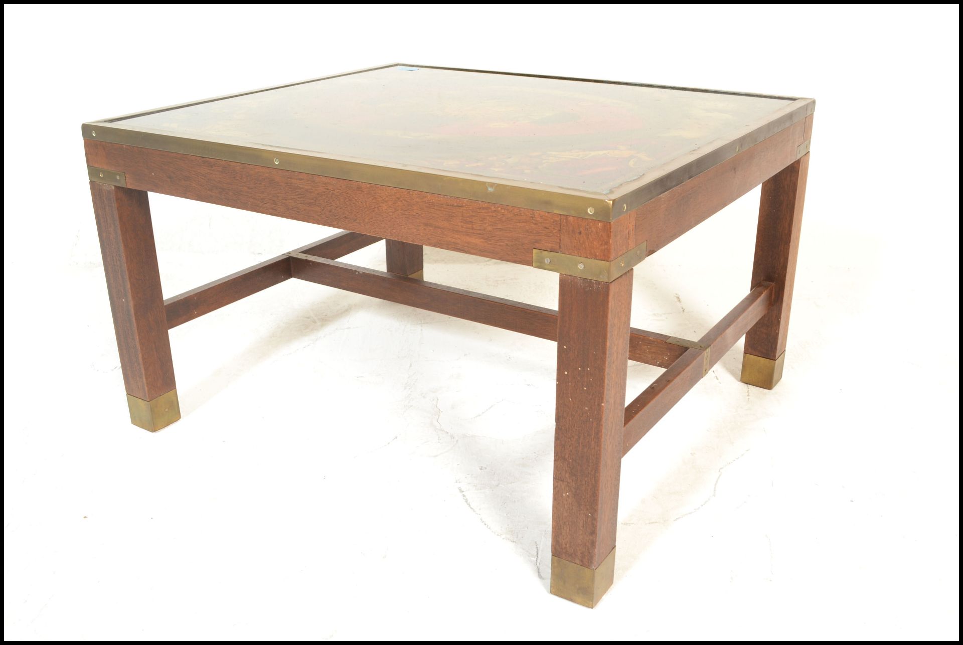 A retro mid century British campaign style coffee / occasional table being raised on mahogany legs