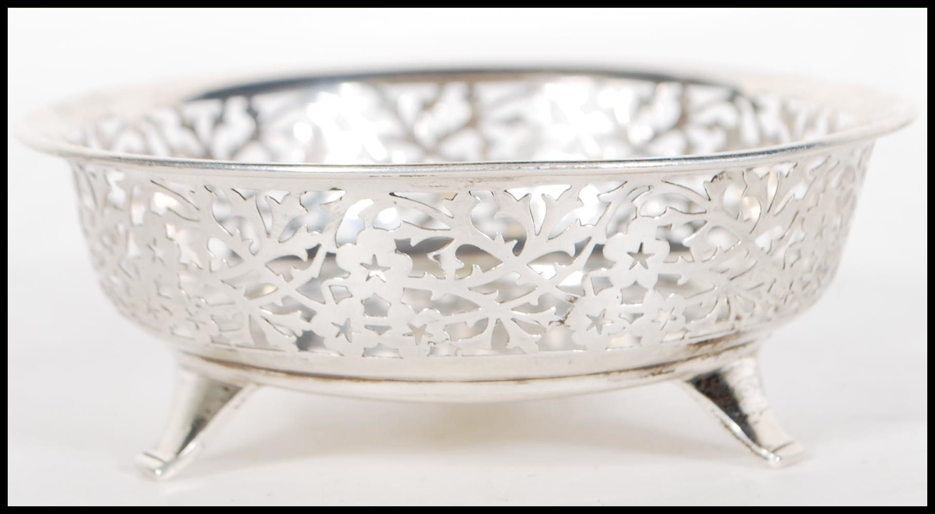 A early 20th Century silver hallmarked dish having pierced foliate decoration raised on three - Image 2 of 6