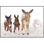 A collection of four ceramic figurines modelled as animals to include a Donkey, another Donkey, a