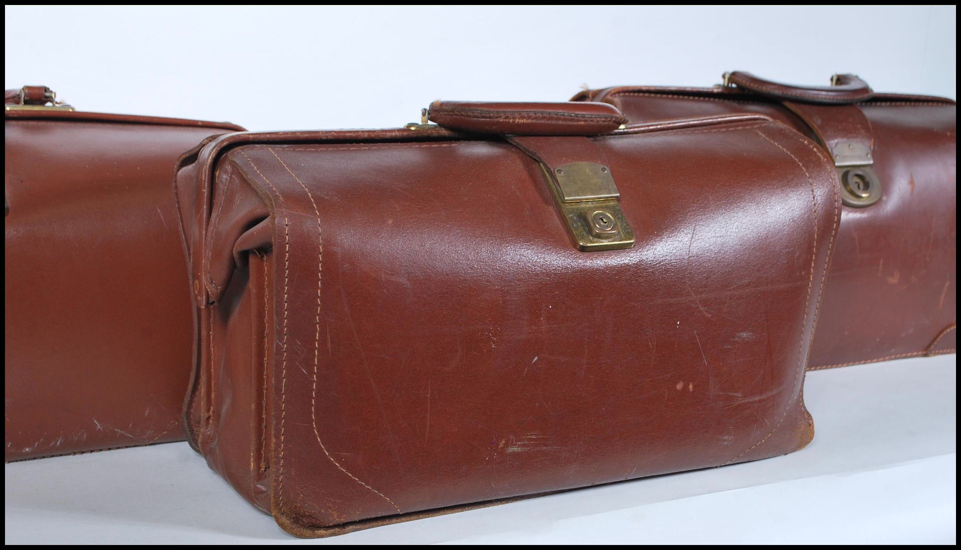 A collection of three vintage early to mid 20th Century Gladstone leather bags. Each having brass - Bild 2 aus 3