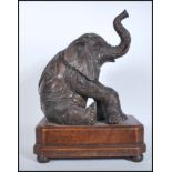 A believed 20th Century cast bronze table top figure of a seated Indian elephant  in the manner of