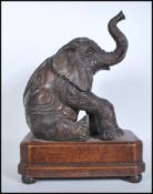 A believed 20th Century cast bronze table top figure of a seated Indian elephant  in the manner of