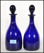 A pair of 20th century Bristol blue glass spirit decanters with stoppers, each with ball finial