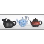 A group of three Chinese teapots dating from the early 20th Century to include one modeled as a