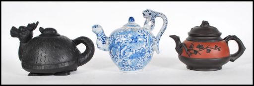 A group of three Chinese teapots dating from the early 20th Century to include one modeled as a