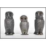 A pair of 19th Century French pewter pepperette condiments in the form of owls, along with another