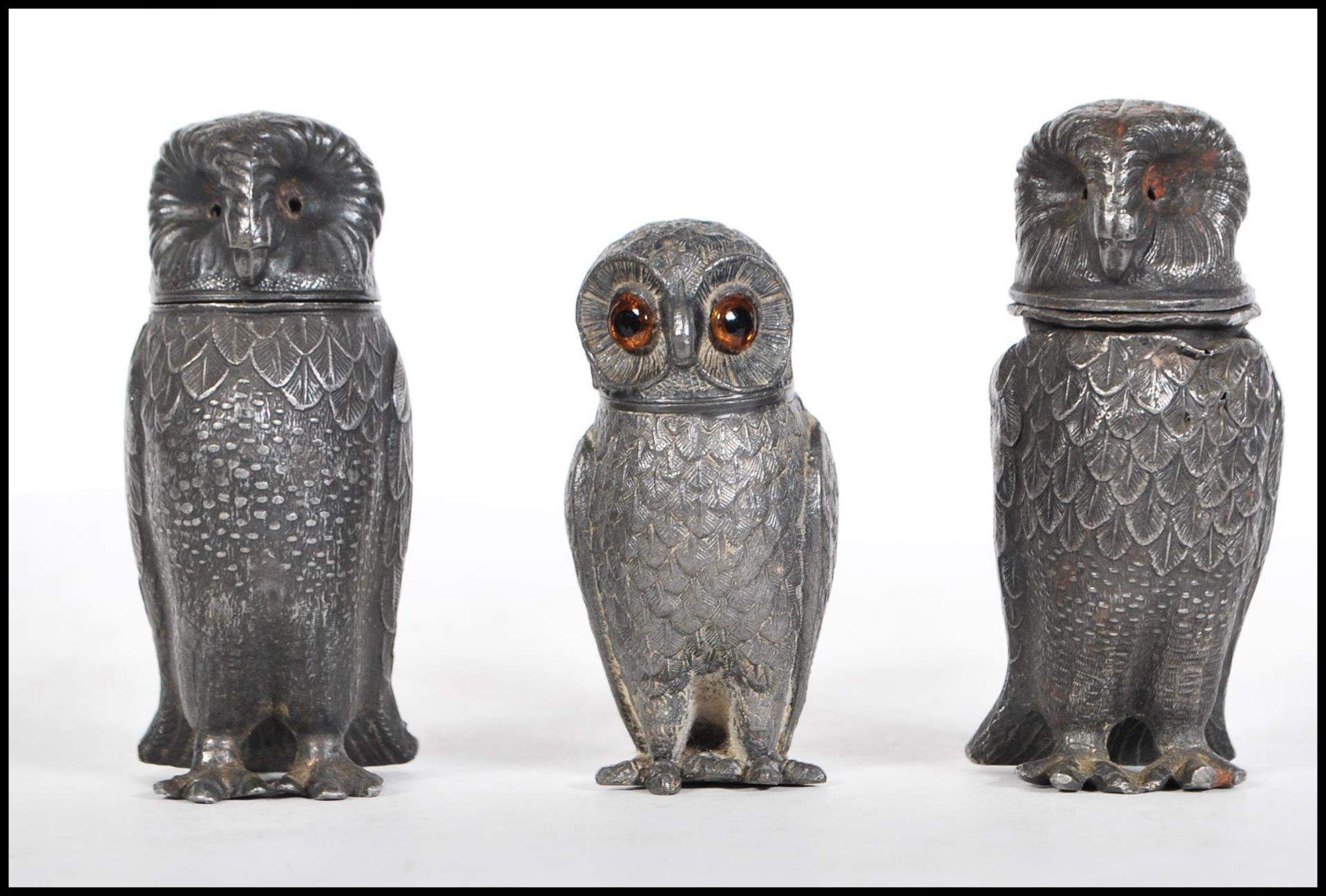 A pair of 19th Century French pewter pepperette condiments in the form of owls, along with another