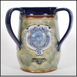 An early 20th century Royal Doulton three handled large loving cup commemorating '  The Coronation