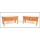 A pair of contemporary oak coffee tables of rectangular form with curved end table tops having
