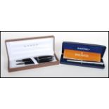 A boxed pen set by Cross consisting of a ballpoint pen and fountain pen finished in black.