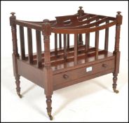 A 20th Century Regency style mahogany Canterbury magazine rack being raised on turned legs with