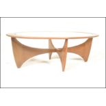 A 1950's mid century teak wood Danish influence coffee table of sputnik / Astro form. Inset glass