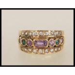 A 9ct gold suffragette style ring set with a row of purple and green stones flanked by two rows of