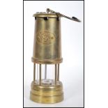 A 20th Century brass miners safety lamp  with hanging hook to the top and applied plaque with a