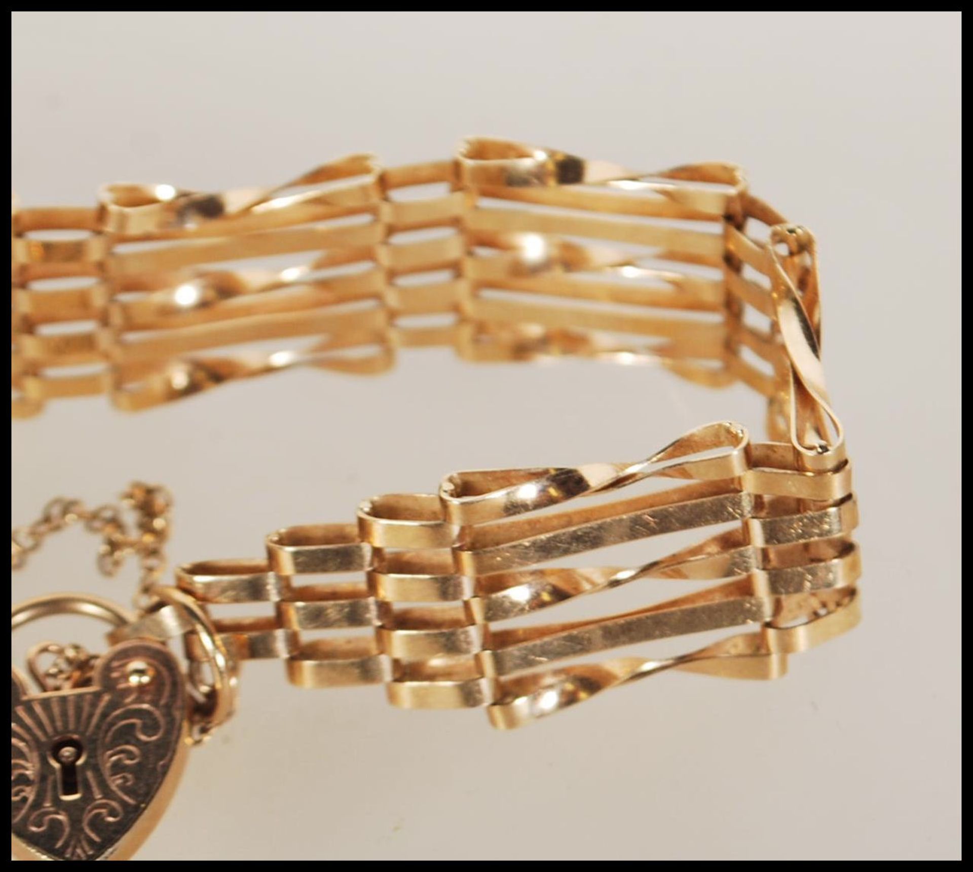 A hallmarked 9ct gold gate bracelet with tapered ends and attached heart-shaped padlock. - Bild 3 aus 5