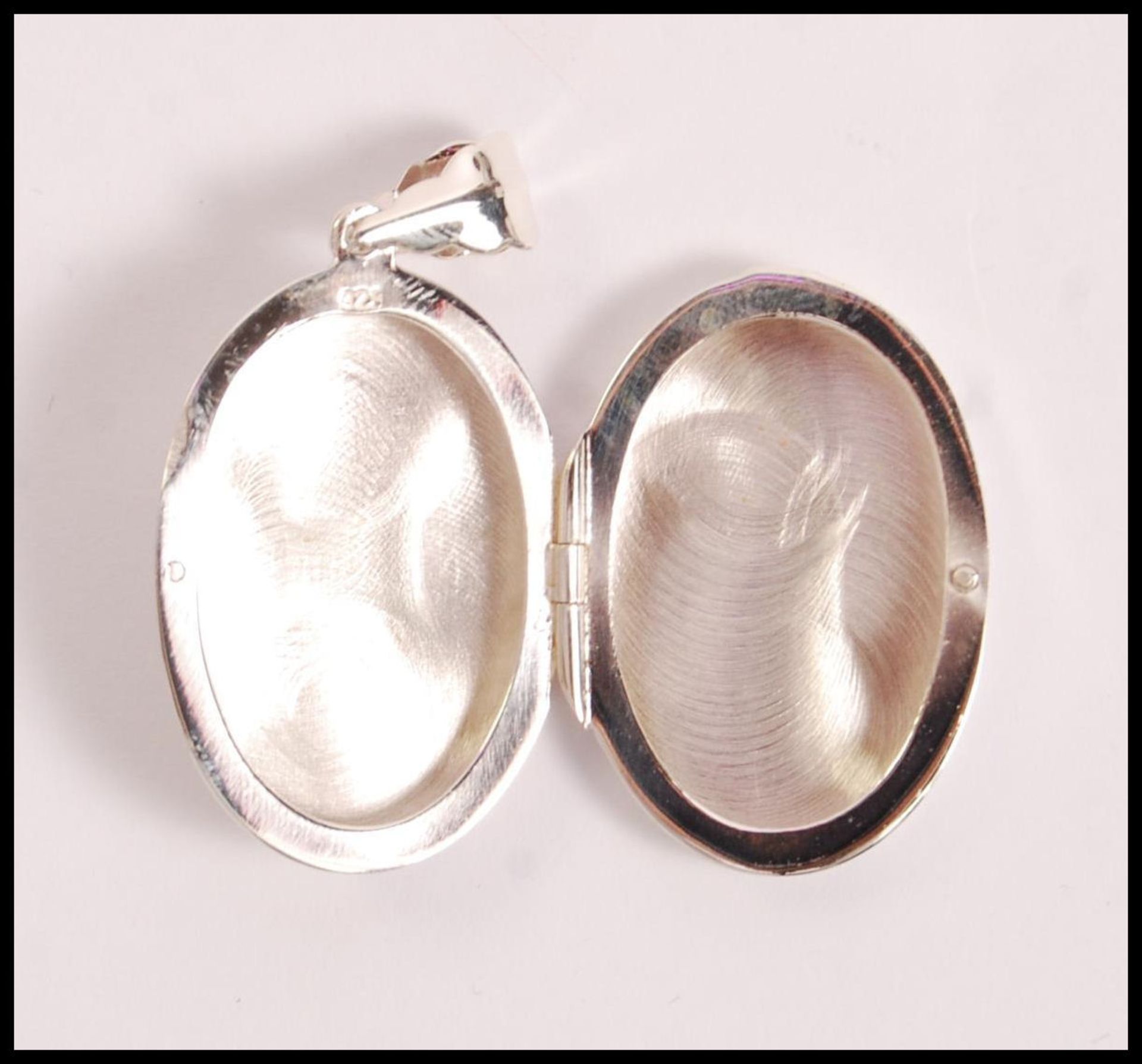 A stamped 925 silver locket of oval form having an embossed scottie dog set with a red stone eye. - Image 3 of 3