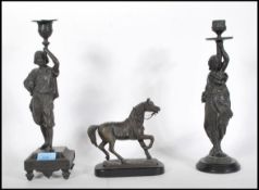 Two late 19th Century Continental spelter near matching candlesticks modelled in the form of a