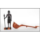 A vintage carved ebony African tribal figure of a tribal warrior with spear in hand, set to a square