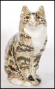A vintage Winstanley ceramic tabby cat figurine modelled in a seated position having a brown mottled