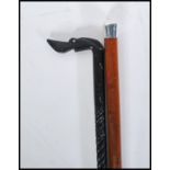 Two 20th Century walking stick canes of tapering form. One having a silver knob handle on a