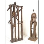 Two unusual 20th century carved African hardwood tribal upright CD rack stands. One in the form of a