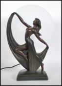 A 20th century Art Deco style table lamp in the form of semi-nude dancer in front of a oval