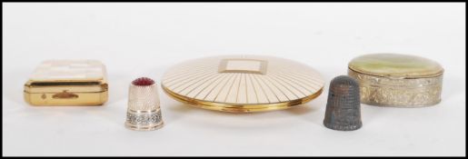 A vintage Stratton powder compact of round form with brushed silvered finish and gilt details, a