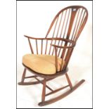 An Ercol beech and elm 20th century large comb back Windsor pattern rocking chair / armchair. Raised