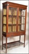 An Edwardian mahogany inlaid vitrine display cabinet being raised on square tapering legs with