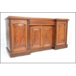 A Victorian 19th century mahogany breakfront inverted sideboard. Raised on a plinth base with