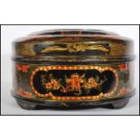 An early Chinese lacquer box of round form having a black ground with having painted cartouche