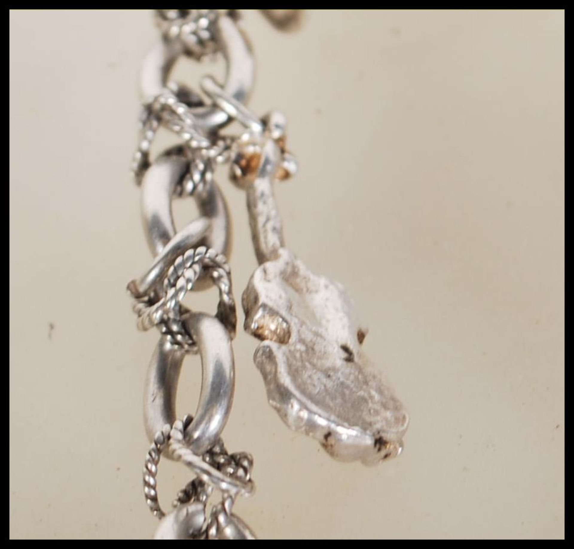 A silver charm bracelet having musical instrument charms to include trumpets, harp, bell violin, - Image 7 of 9