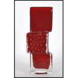 A vintage 20th century Whitefriars Drunken Bricklayer style glass vase in a dark red colourway. In