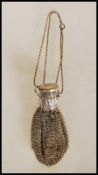 A vintage mid 20th Century white metal chain link bag having an extendable neck with round cap to