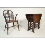 A 19th century beech and elm Windsor chair / armchair raised on turned legs with saddle seat and