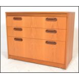 A retro 20th Century teak wood chest of drawers having a configuration of three graduating drawers
