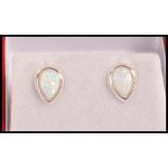 A pair of silver stud earrings set with pear shaped opal panels. Weight 1.1g.