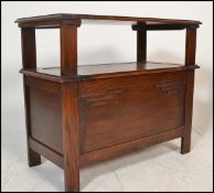 A 1920's oak monks bench / hall settle. Of plain form with stile legs having hinged seat with a fold