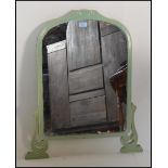 A 1920's Art Deco mirror finished in green having shaped dome top raised on music note feet.