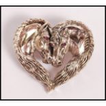 A stamped 925 silver heart shaped brooch in the form of two horses with red stone eyes. Weight 18.
