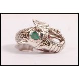 A stamped 925 silver ring in the form of an elephant set with a pear shaped emerald to the head,