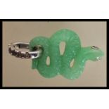 A carved jade pendant in the form of a snake having ruby and silver eyes on a silver 925 pendant