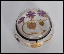 An early 20th Century Art Nouveau glass powder compact, having hinged lid and hand painted gold