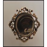 A 19th Century Victorian gold plated mourning brooch having an oval window to the front set with