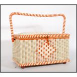 A vintage retro 20th Century sewing box having white and orange wicker body, hinged lid opening to